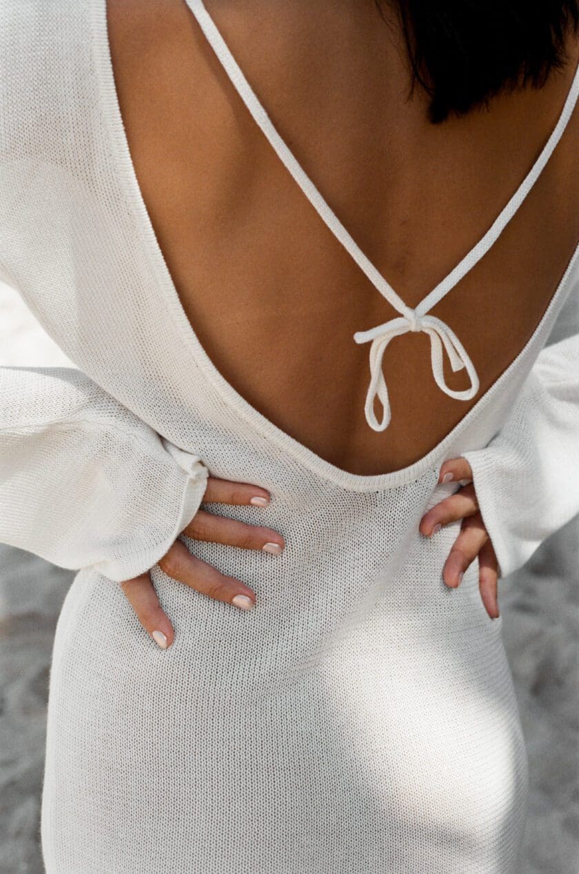 Up close View of Cinnamon Swimwear off white Mini Dress Coverup ties fastenings and low cut back