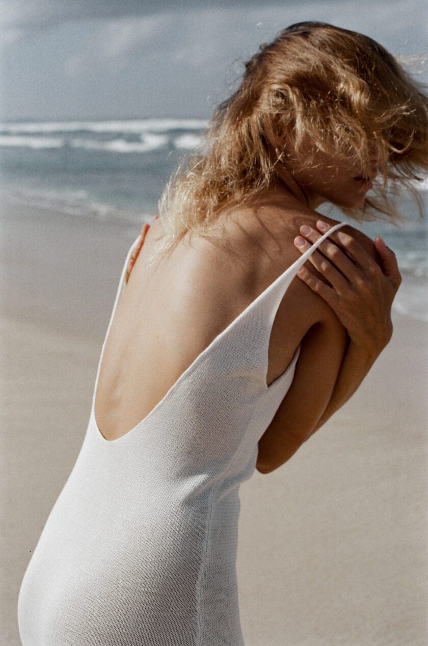 Back View of Model wearing Cinnamon Swimwear Off-white Maxi Cover-Up Dress showing low cut back